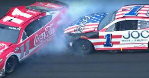 Denny Hamlin in the red number 11 NASCAR car is wrecked by Ross Chastain in the red and white striped number 1 NASCAR car