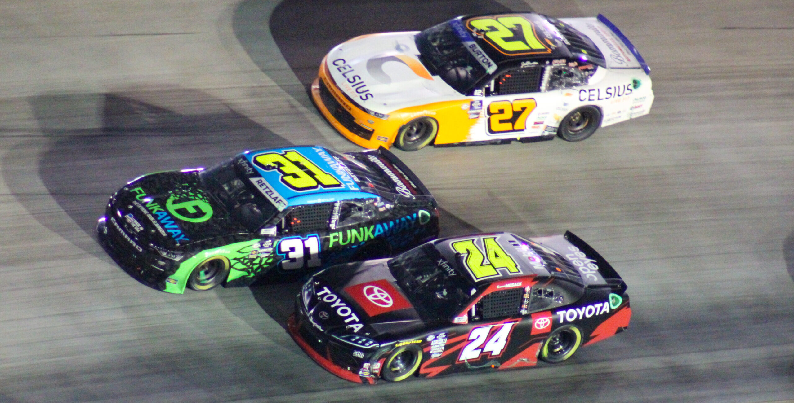Connor Mosack racing at the 2023 Xfinity Bristol Night Race with Parker Retzlaff and Jeb Burton to his outside