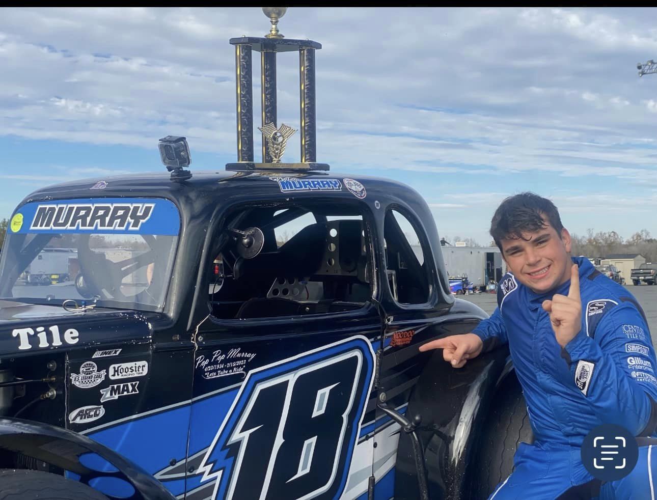 Miles Murray poses with his Legend car and trophy.