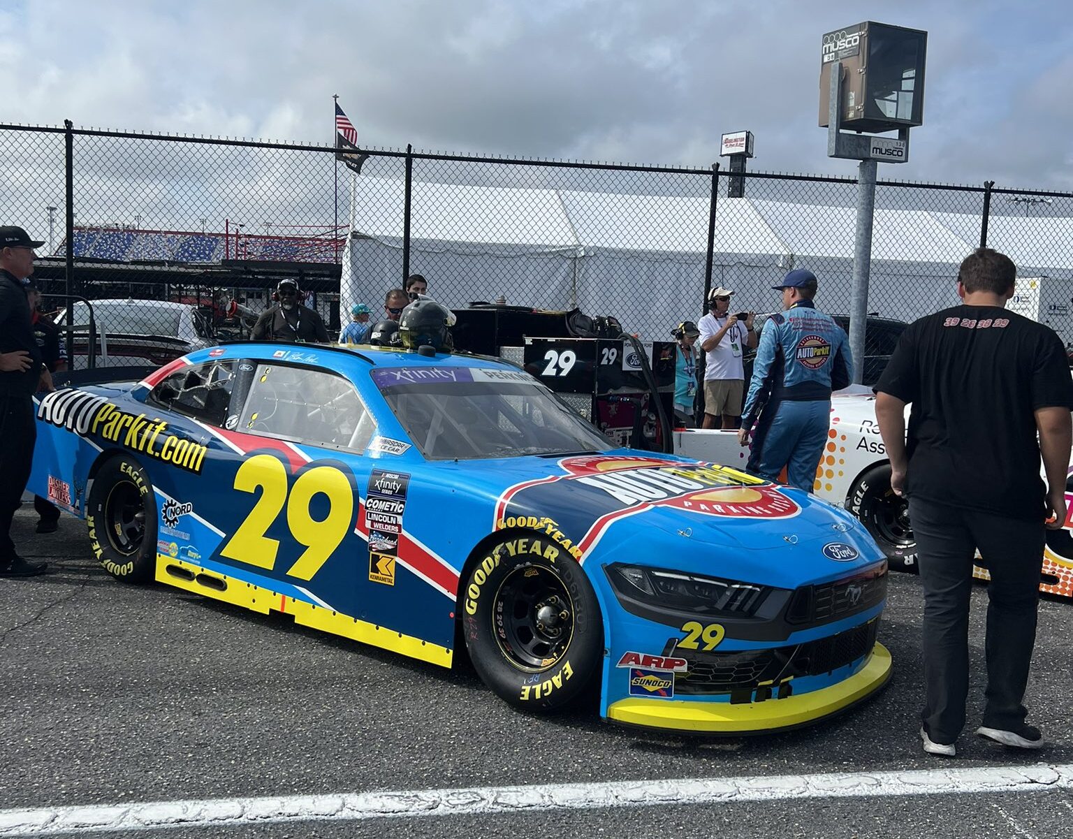 Blaine Perkins waits for practice beside his No. 29 Ford Mustang.